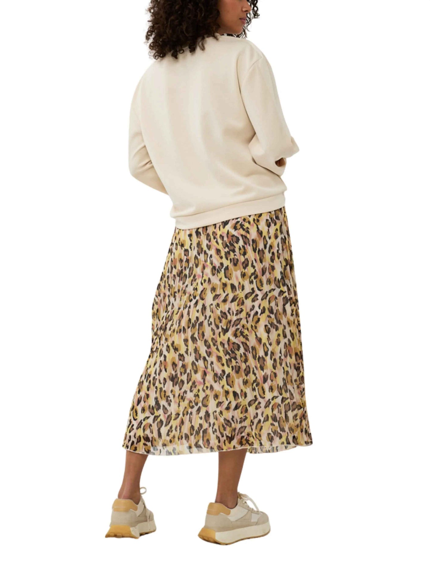 Falda midi estampado animal print con suéter beige y zapatillas casuales
