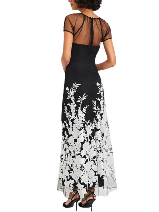 Vista posterior de vestido largo negro con espalda de tul transparente y bordado floral.