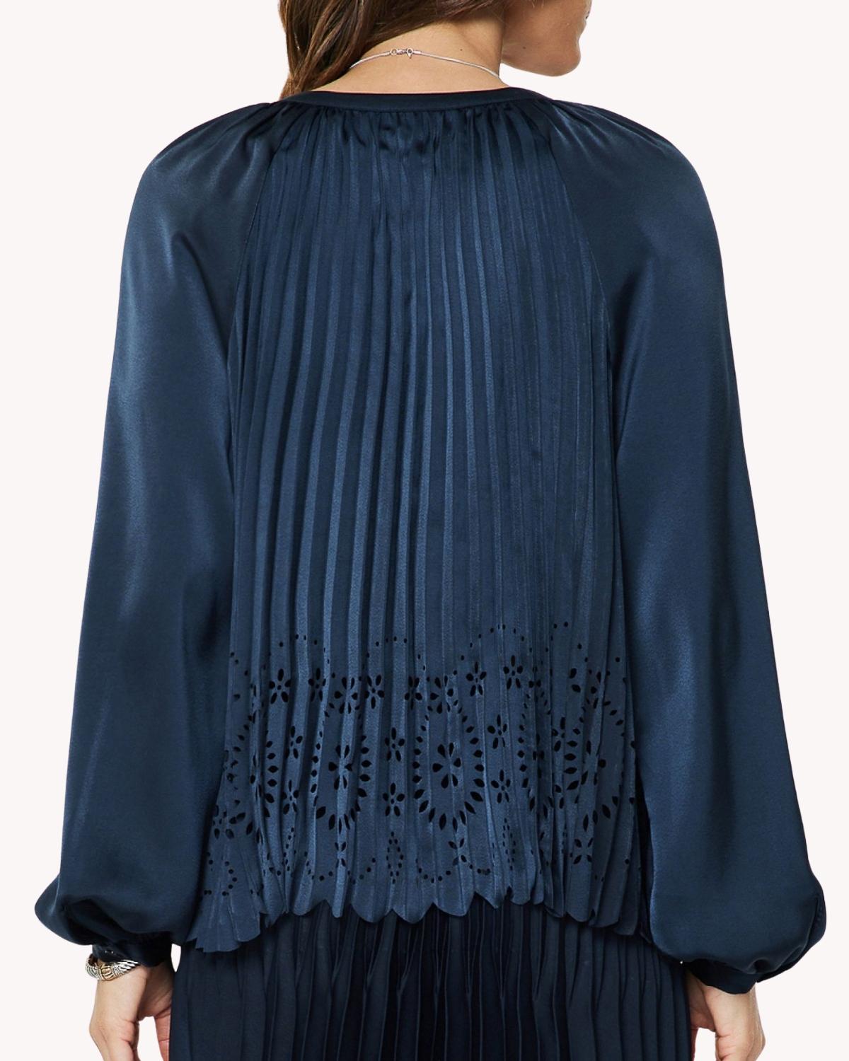 Blusa plisada calada azul marino vista posterior con plisado vertical y calado floral