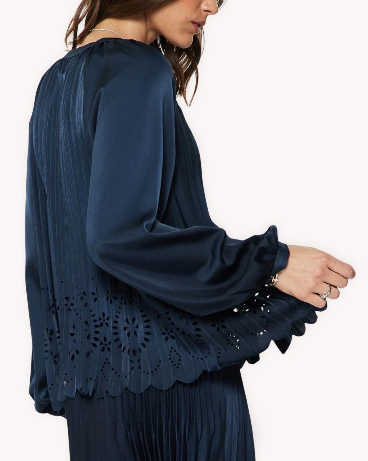 Blusa plisada calada azul marino vista lateral posterior con manga larga y bajo festoneado