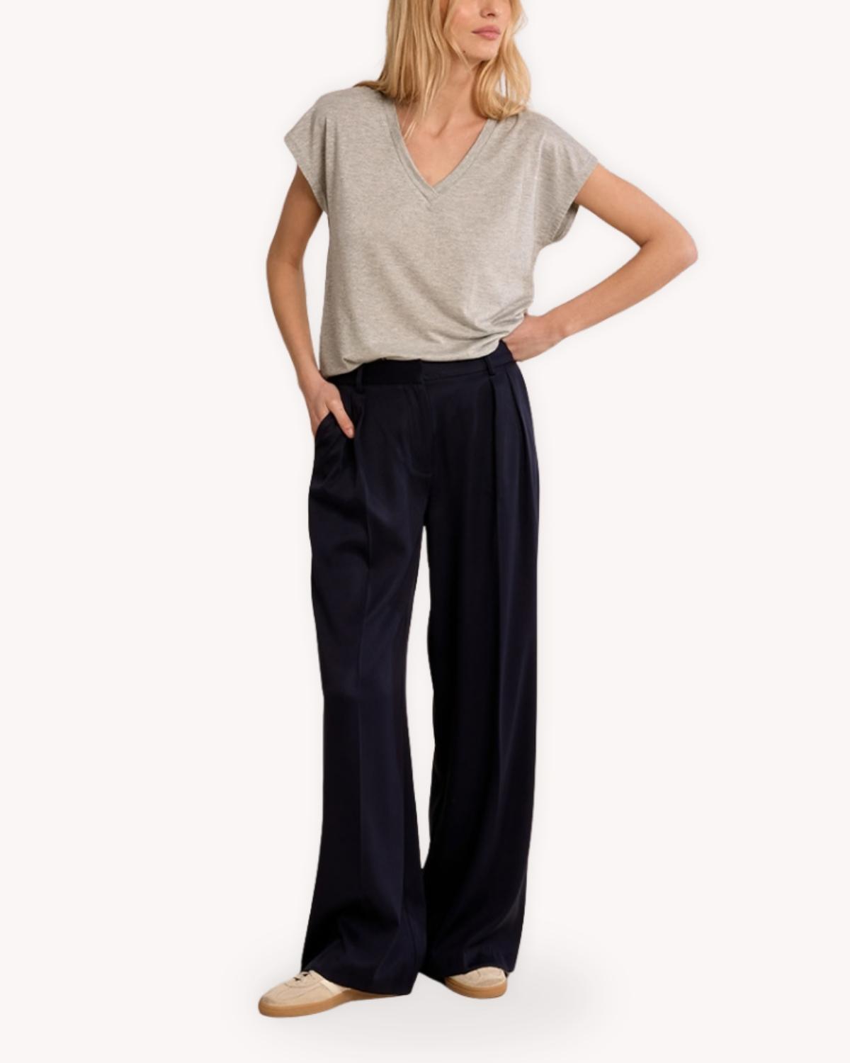 Playera metalizada plata cuello V vista completa combinada con pantalón azul marino