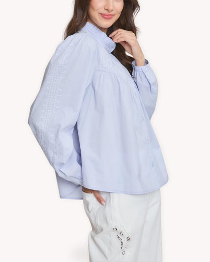 Blusa babydoll bordada azul vista lateral con manga larga y canesú fruncido