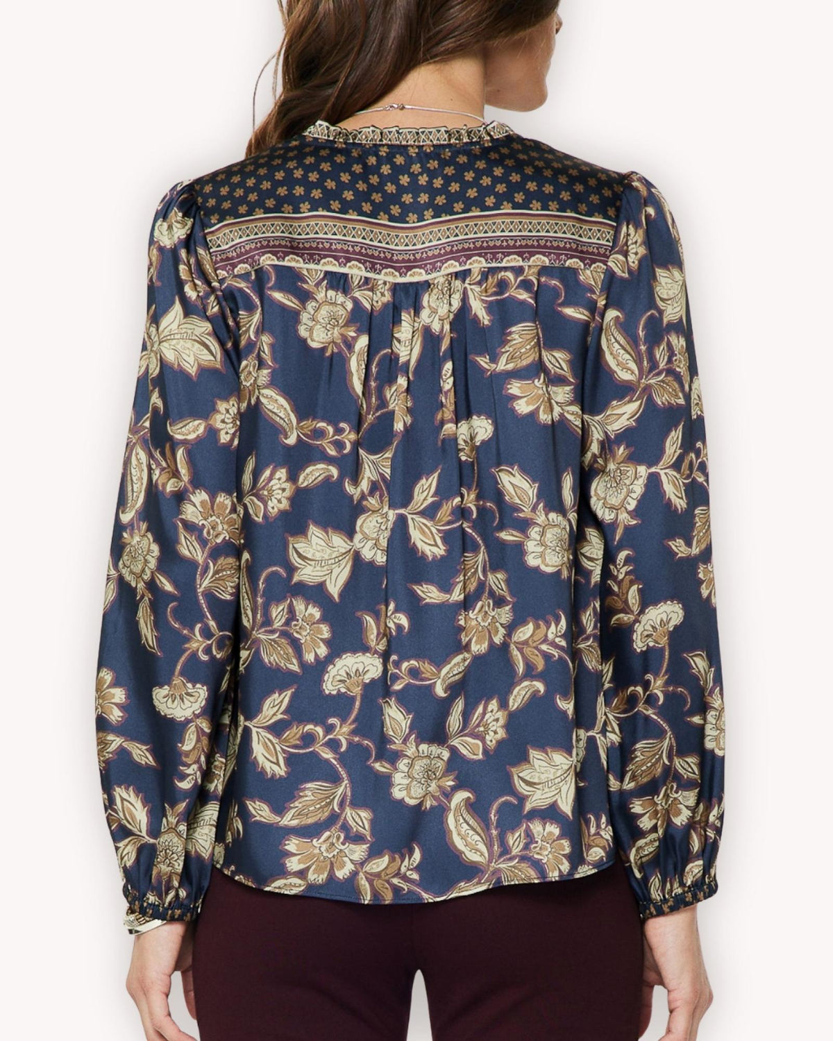 Vista posterior de blusa floral azul con cenefa estampada