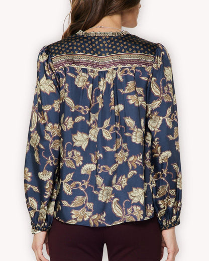 Vista posterior de blusa floral azul con cenefa estampada