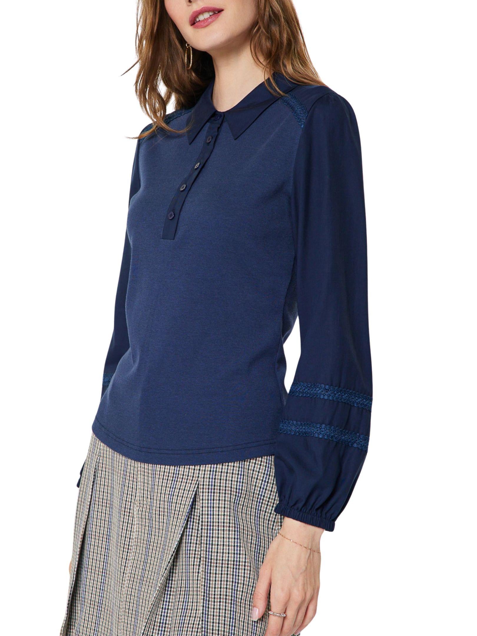 Detalle de blusa polo tejida con cuello camisero y mangas largas decoradas.