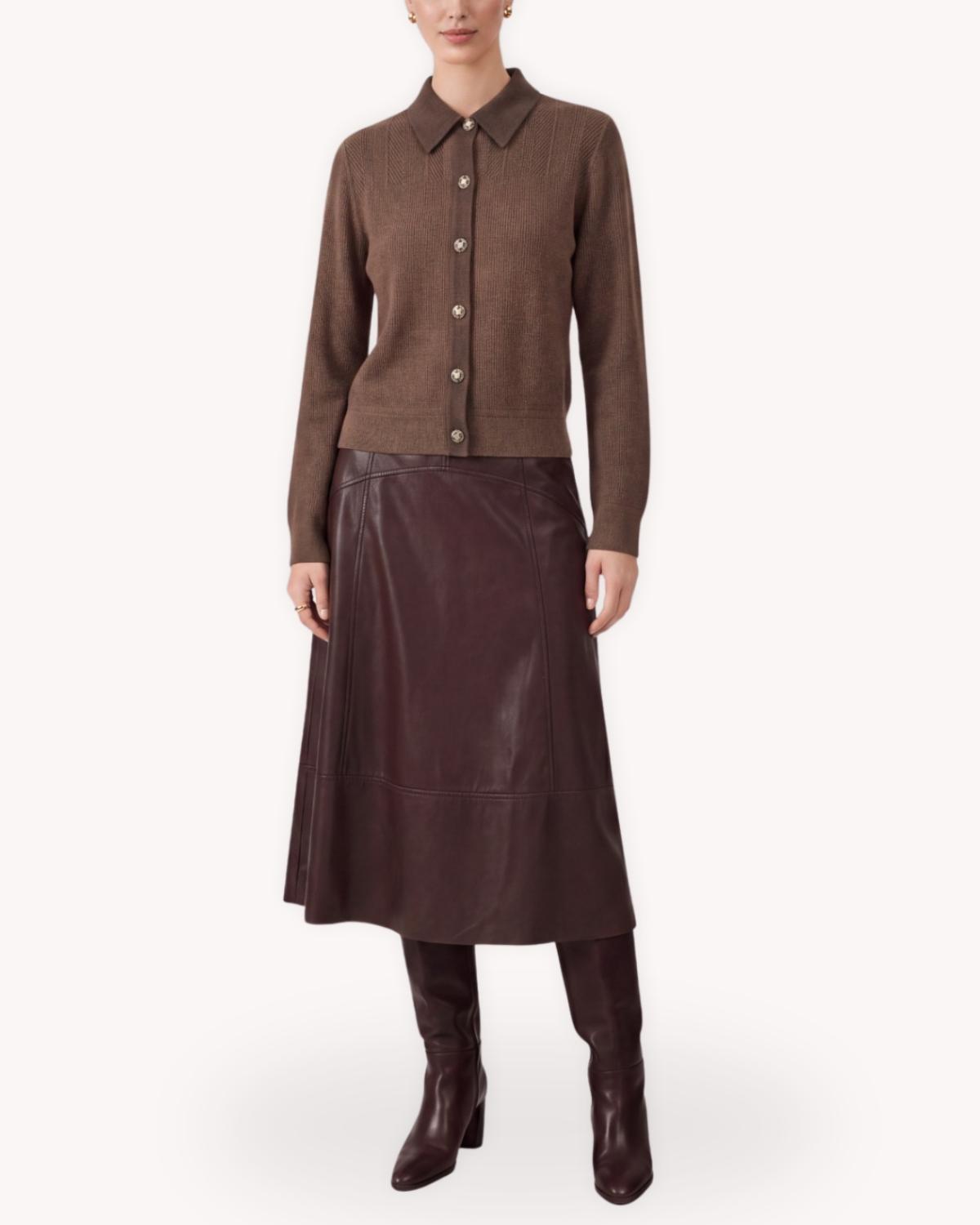 Cárdigan café con cuello camisero, botones dorados y manga larga, combinado con falda midi