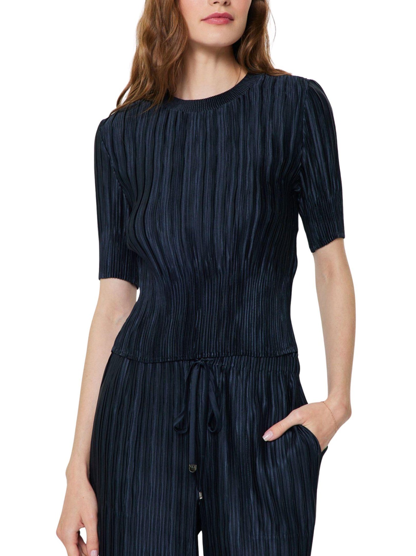 Detalle del tejido satinado plisado de blusa azul marino para mujer.