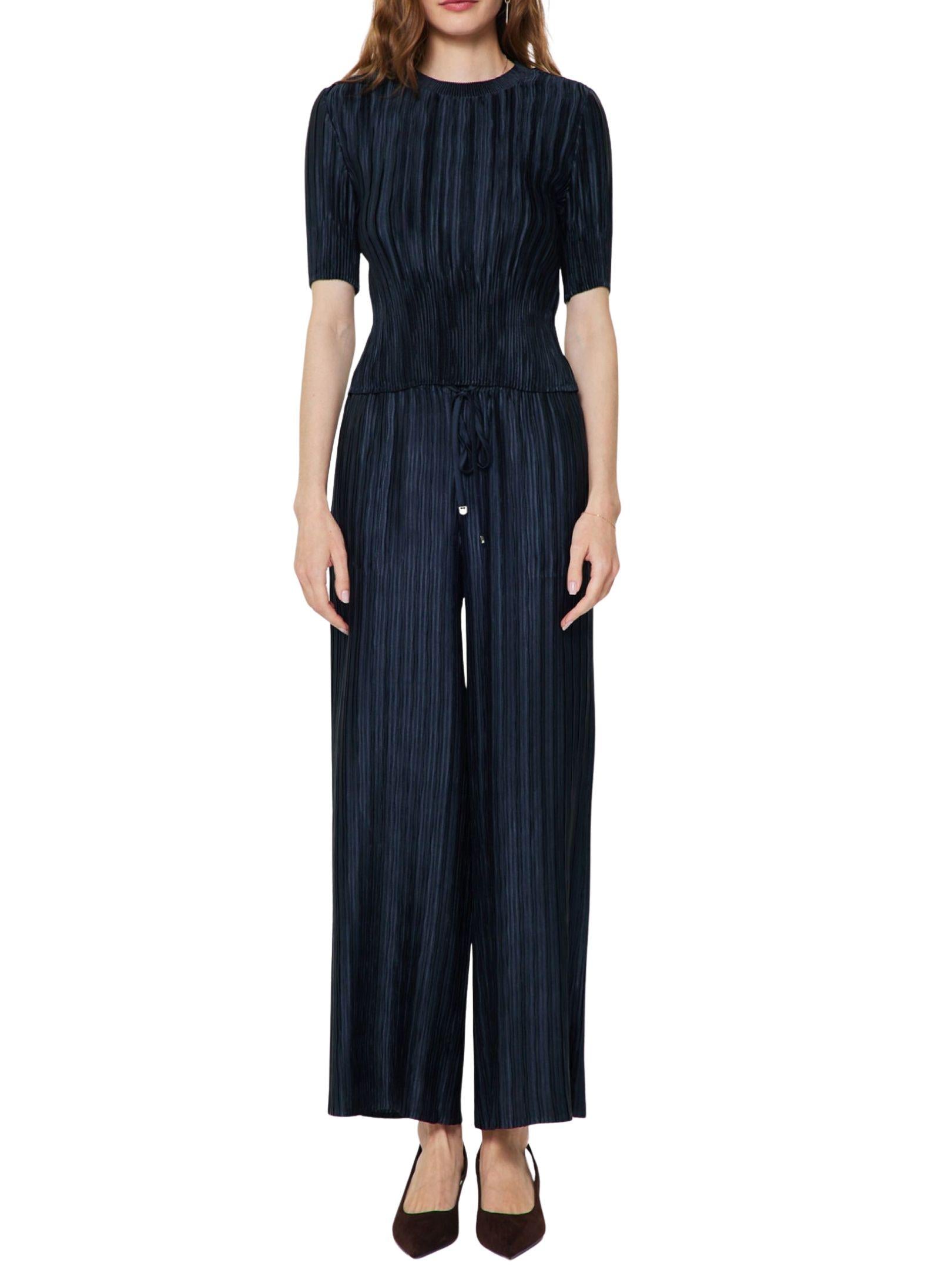 Conjunto satinado plisado azul marino con blusa de manga corta y pantalón de pierna amplia.