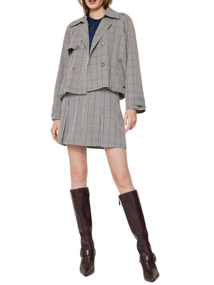 Descubre esta gabardina corta de cuadros con terminado tipo globo, doble botonadura y silueta moderna. Ideal para looks elegantes de otoño e invierno.