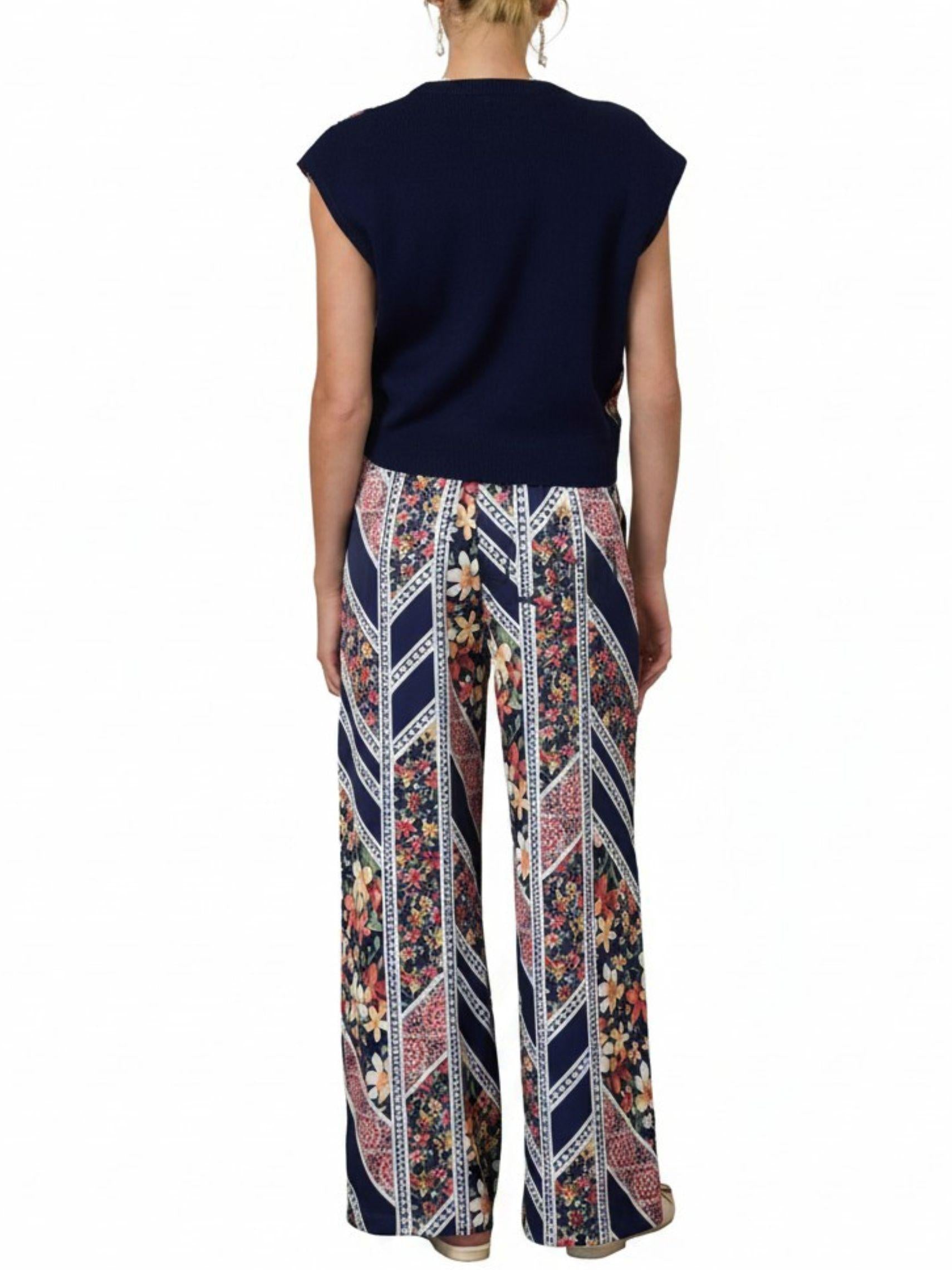 Vista posterior de set de blusa con espalda de punto y pantalón de satín floral con cintura elástica.