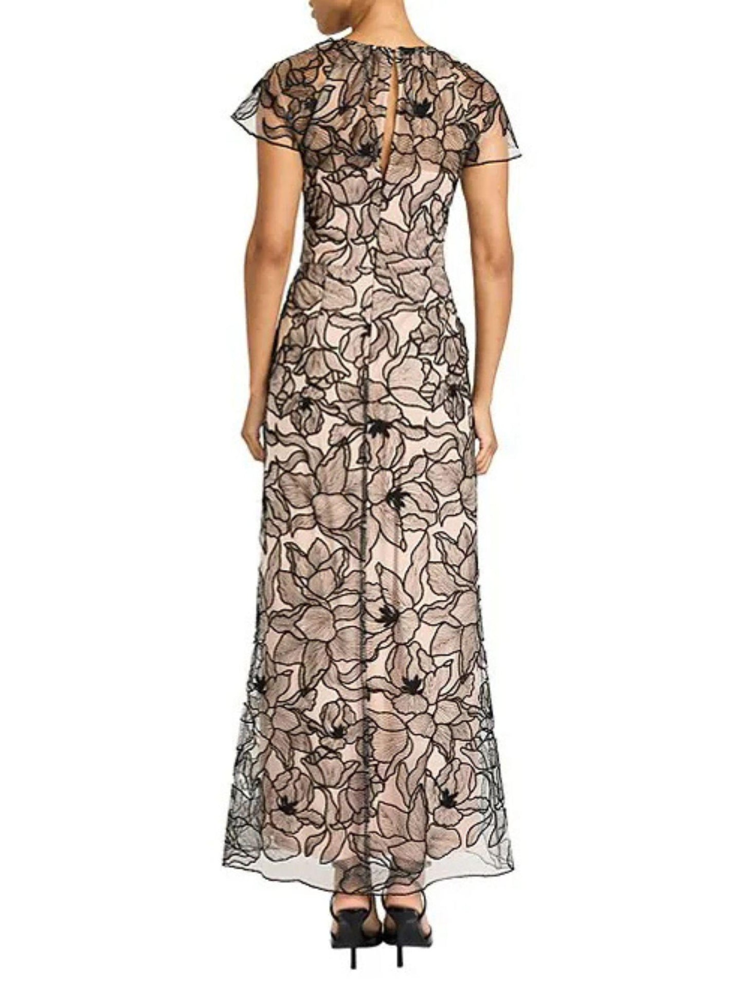 Vista posterior de vestido largo bordado floral con transparencia de tul y abertura en el escote.