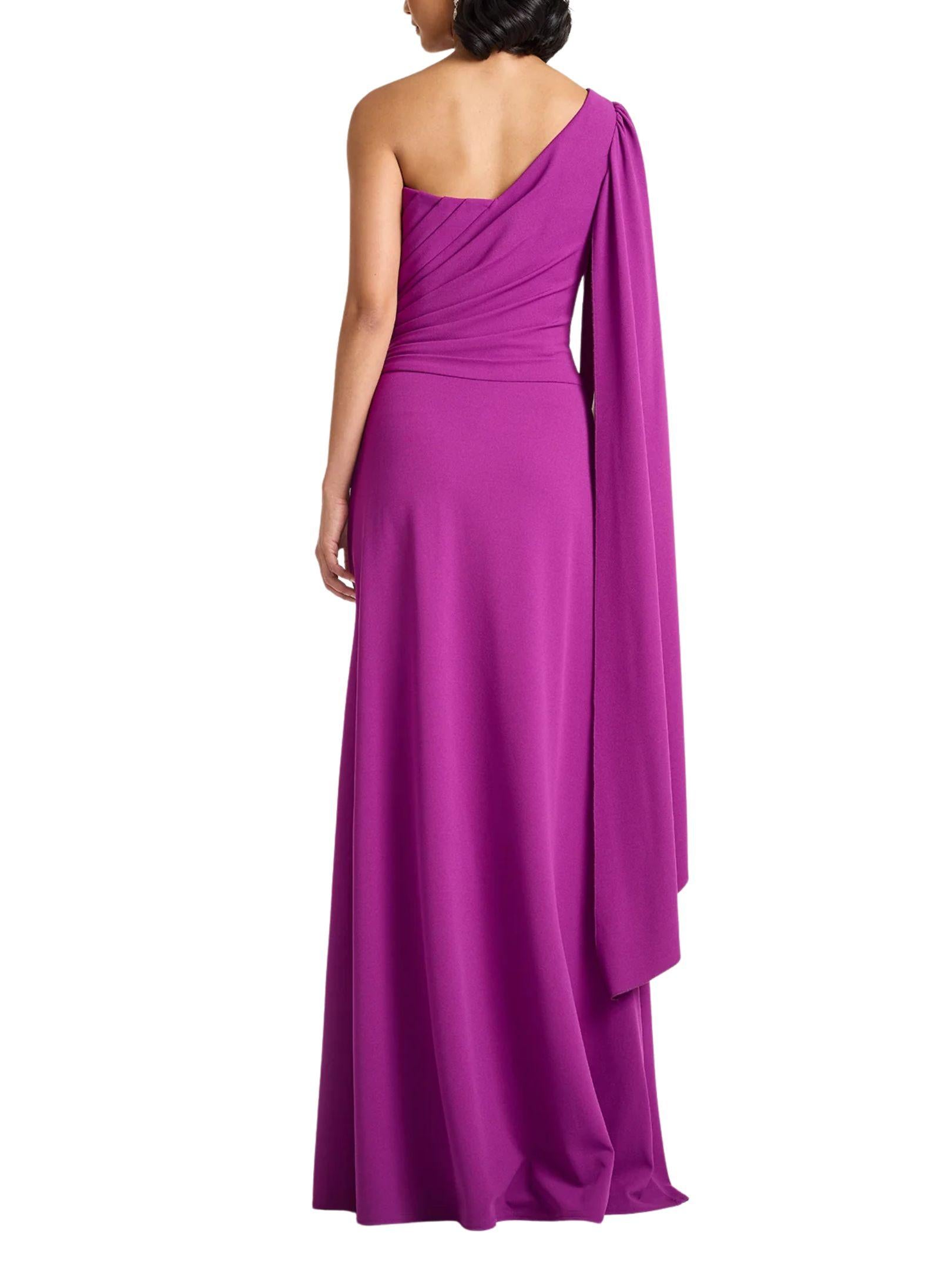 Vista posterior de vestido largo fucsia de un hombro con manga tipo capa de Tadashi Shoji.