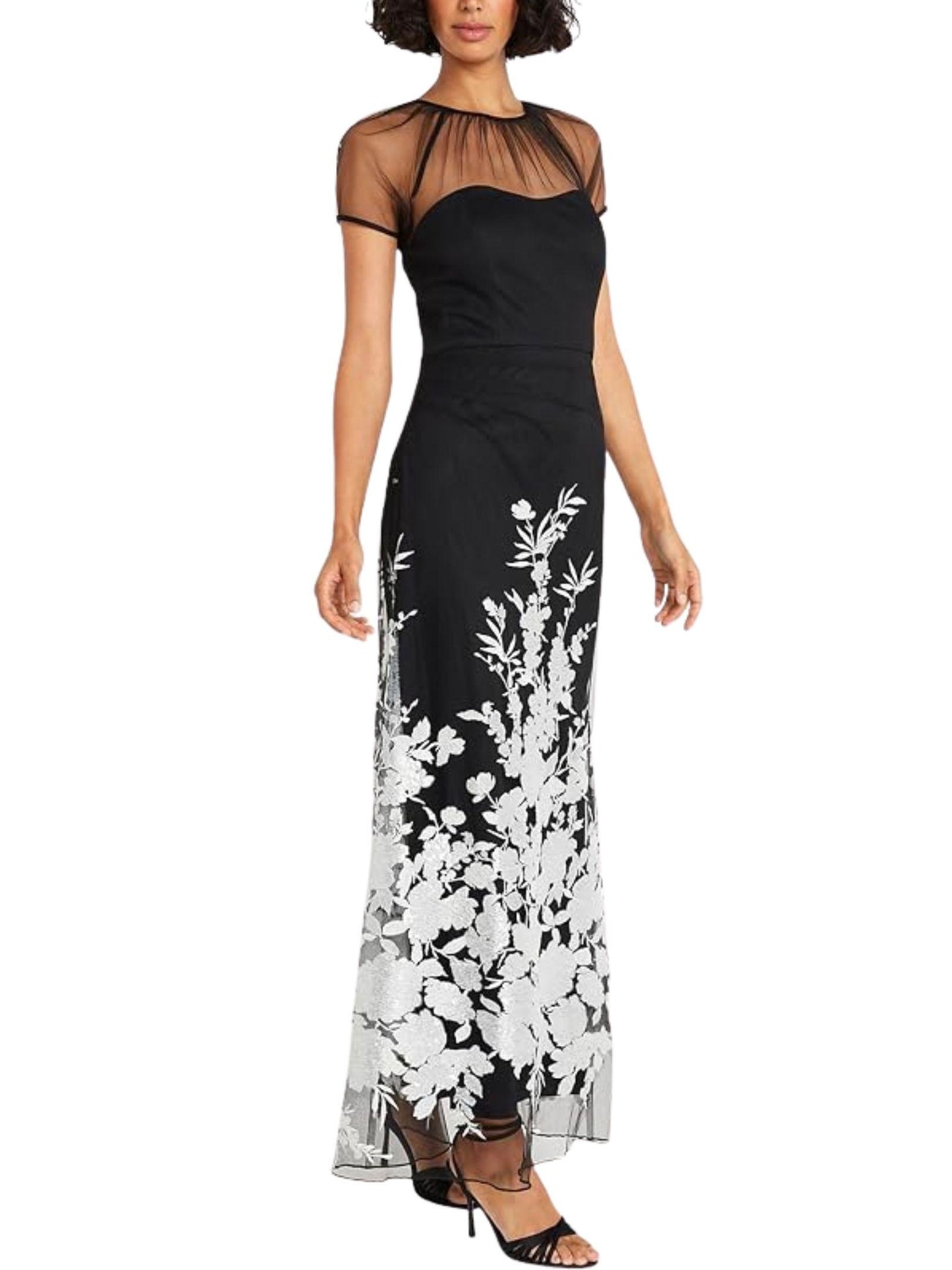 Vista lateral de vestido largo negro con bordado floral y transparencias de tul.