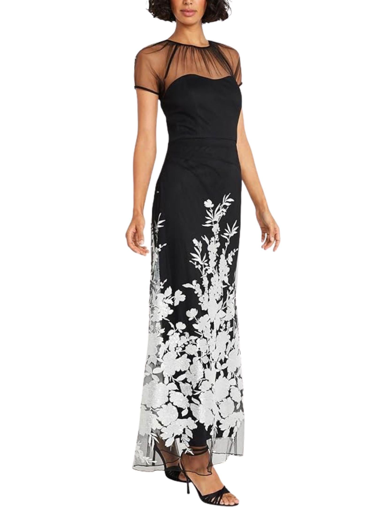 Vista lateral de vestido largo negro con bordado floral y transparencias de tul.