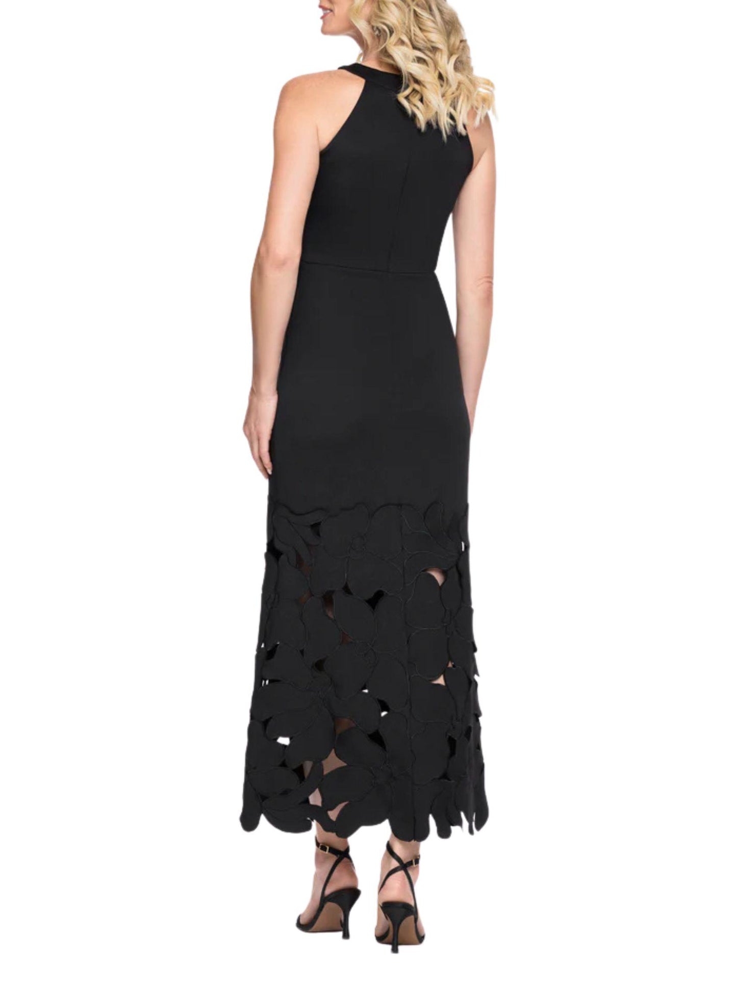 Vestido largo negro de tejido ponte con cuello halter y falda de flores caladas, vista frontal.