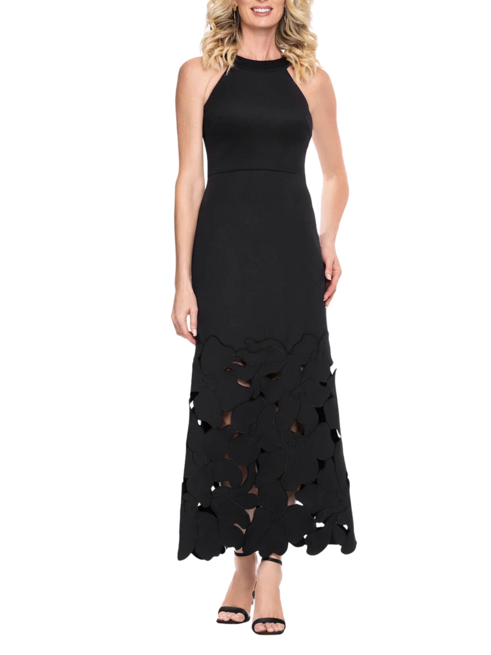 Vestido largo negro de tejido ponte con cuello halter y falda de flores caladas, vista frontal.