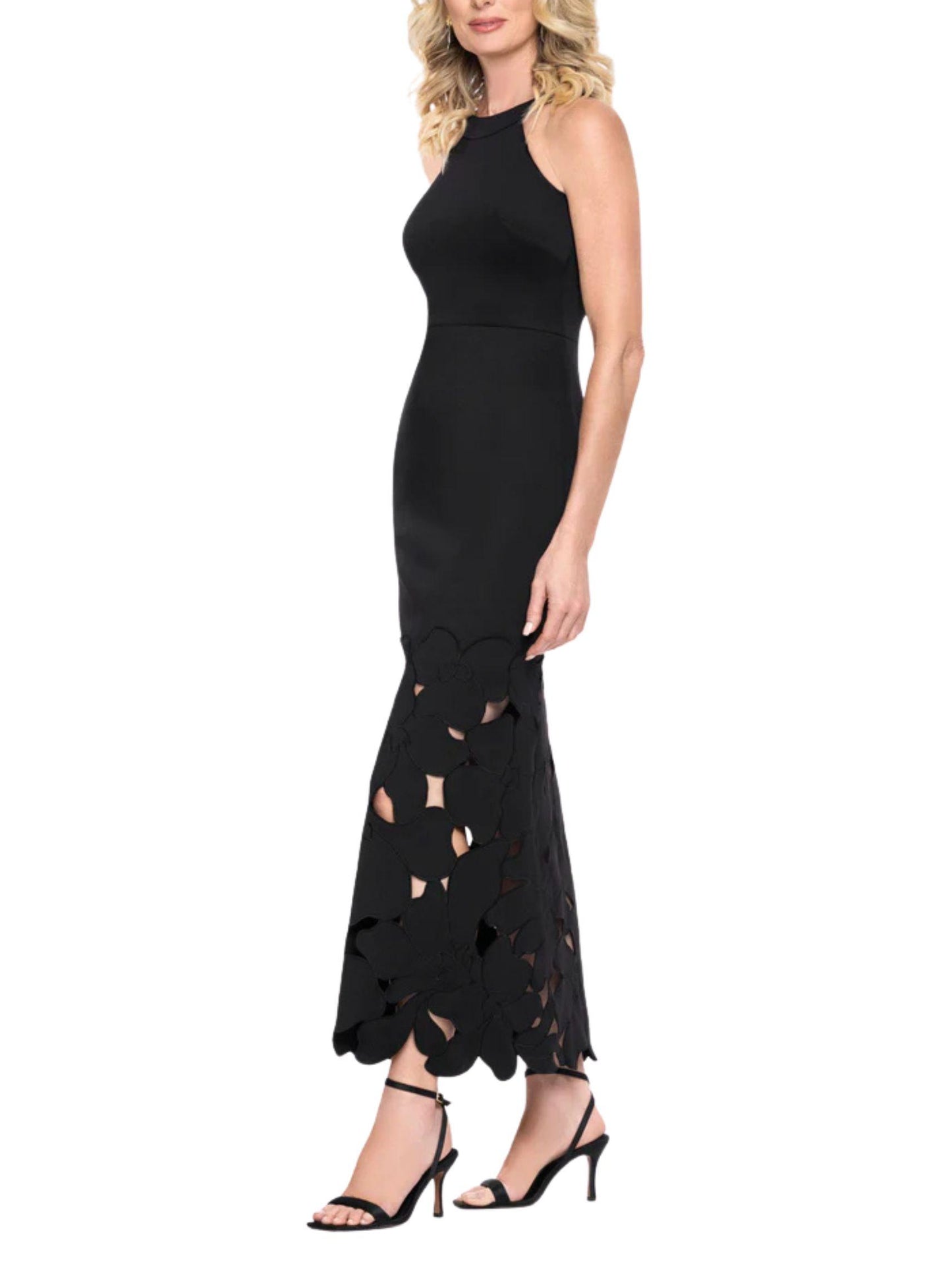 Vista lateral de vestido largo negro con cuello halter y falda con flores caladas.