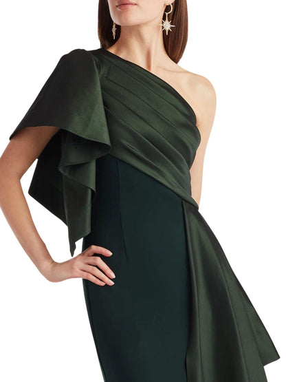 Detalle de vestido largo verde asimétrico con drapeado diagonal y diseño sofisticado.